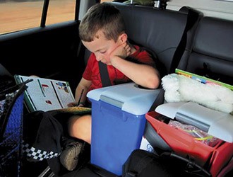 boy reading in a car on a camping trip