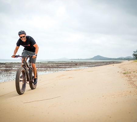Man riding Dyson bike on the beach