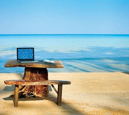 Laptop on a bench at the beach