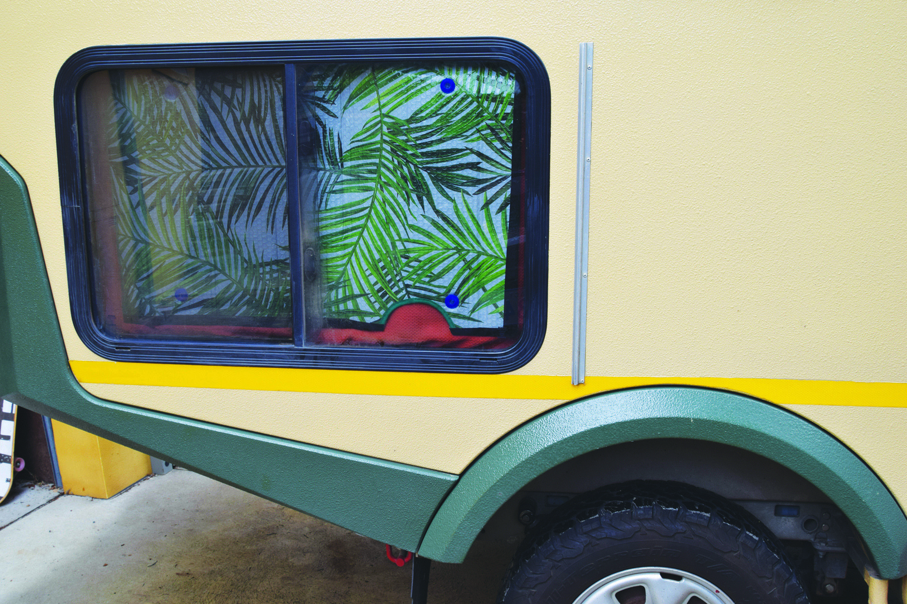 A caravan window with a sun visor