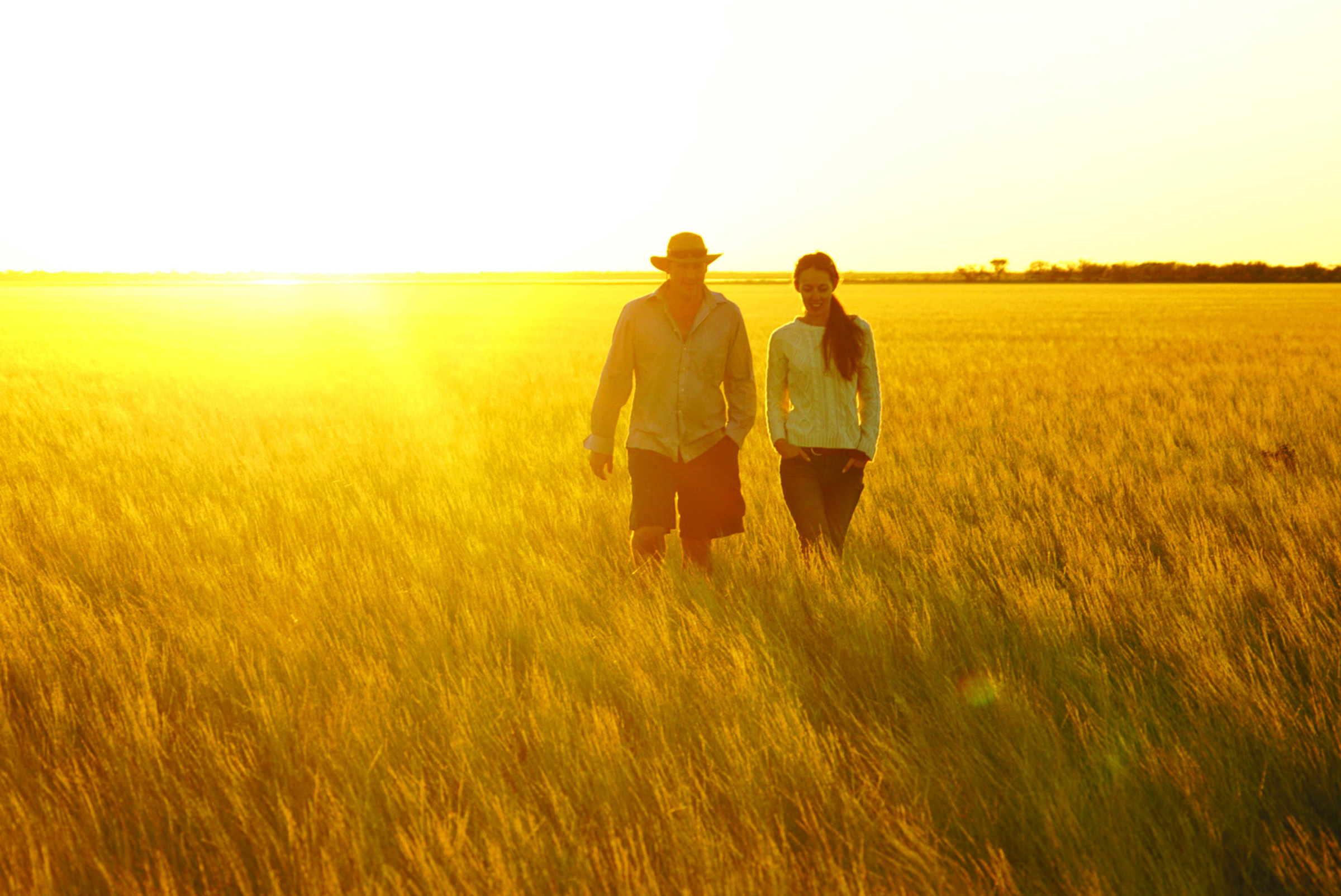 Two people walking in a field