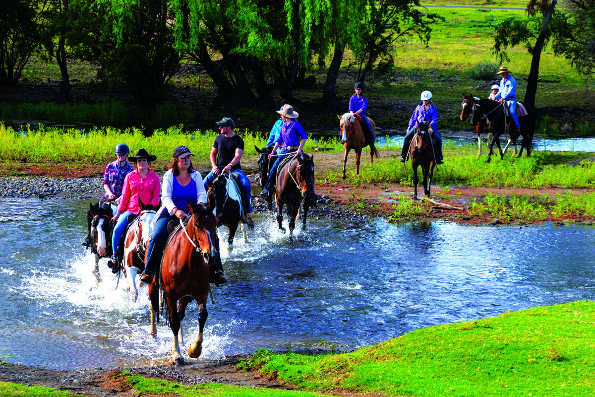 People riding horses through water