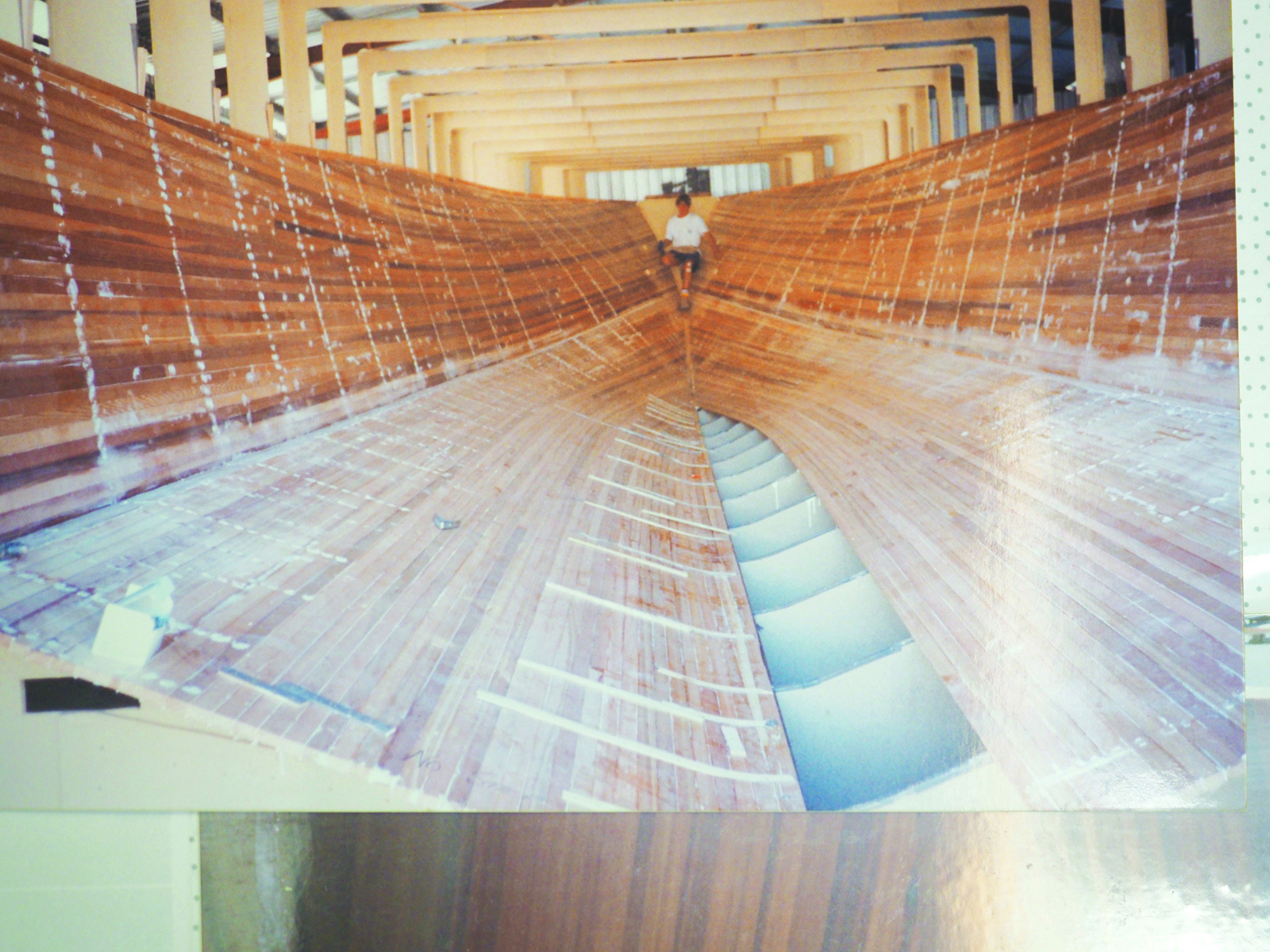 Man sitting inside empty boat hull