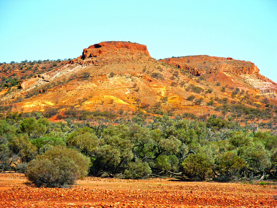 Rock formations in the distance with trees and bushes in the foreground