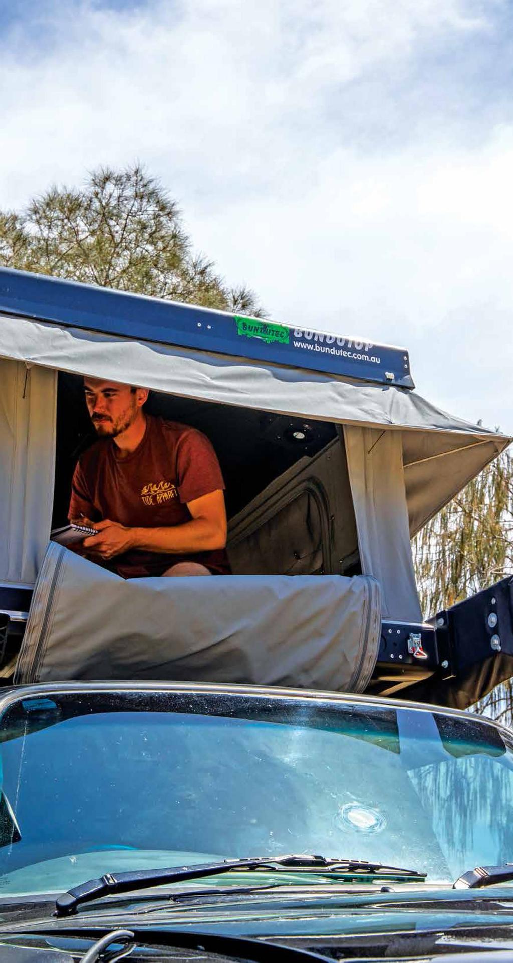 person sitting inside roof top tent